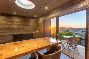 a wooden dining room with a table and a large window at Surfpro in Pichilemu