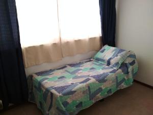 Cama pequeña en habitación con ventana en Apartamento 2 dormitorios en Av. Gorlero, en Punta del Este