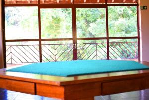a bed in a room with a large window at Hotel Moinho de Pedra in Serra Negra