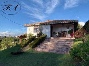 a house with stairs in front of it at Finca Alejandria in Guatapé