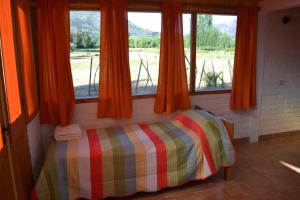 a bedroom with a bed in a room with windows at Cabaña en El Hoyo in El Hoyo