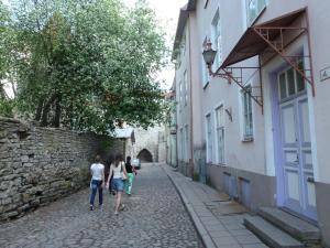 a group of people walking down a street at 16eur - Old Town Munkenhof in Tallinn