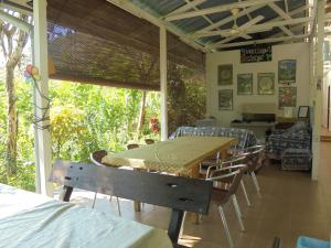 a dining room with a table and chairs and a couch at Moonriver Lodge in Ladang Pangoi