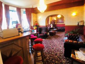 a bar in a pub with chairs and a counter at Ilfracombe House Hotel - near Cliffs Pavilion in Southend-on-Sea