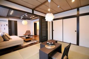 ein Wohnzimmer mit einem Sofa und einem Tisch in der Unterkunft One’s Villa Sapporo House in Sapporo