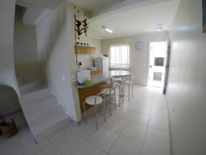 cocina con encimera y taburetes en una habitación en A155 Duplex 2 quartos Bombas, en Bombinhas