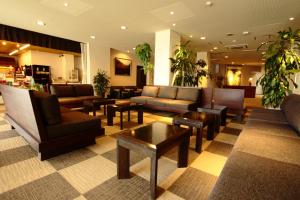 a lobby with couches and tables and plants at Kikuchi Grand Hotel in Kikuchi