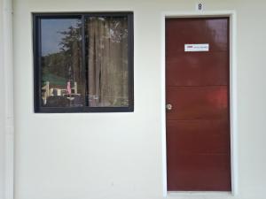 a door to a house with a window at DMS Apartelle in Los Baños