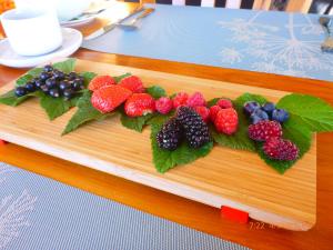 a bunch of fruit on a wooden cutting board at Fran and Frankie's Bed & Breakfast in Luggate