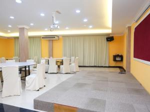 a conference room with white tables and white chairs at Rayyan Soffea Hotel in Kota Bharu