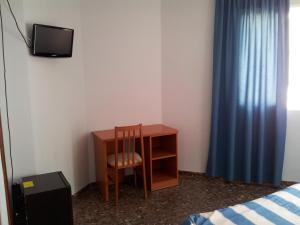 a room with a desk and a chair and a tv at Hotel Costa San Antonio in Cullera
