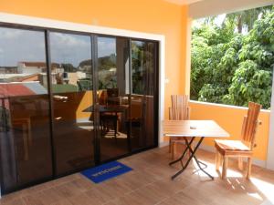 Cette chambre dispose d'une grande fenêtre et d'une table avec des chaises. dans l'établissement The Blue Pagong, à Puerto Galera