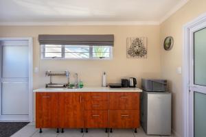 a kitchen with a sink and a refrigerator at Pro Moni's Guesthouse in Muizenberg