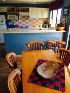 a kitchen with a wooden table with chairs and a tableasteryasteryasteryasteryastery at Beautiful Retreat by the Beach - 1 Lecaille Court in Dunsborough