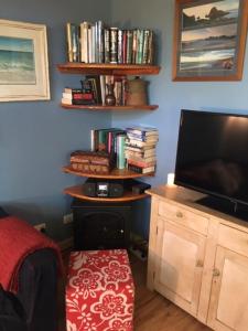 a bedroom with a television and a shelf with books at Beautiful Retreat by the Beach - 1 Lecaille Court in Dunsborough