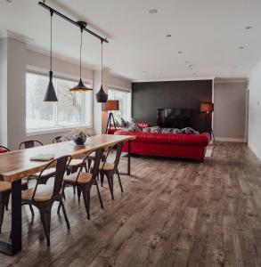 Una sala de estar con una mesa y un sofá rojo. en Ski-in, Ski-out Hatsuyuki Apartments, en Hakuba