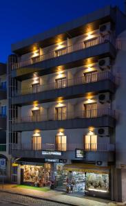um prédio de apartamentos com luzes acesas à noite em Residência S. Francisco em Fátima