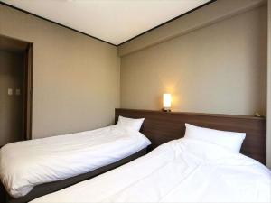 two beds sitting next to each other in a room at Hotel Sun Plaza Sakai in Sakai