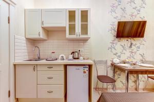 a small kitchen with a refrigerator and a table at Guest rooms on Marata 10 in Saint Petersburg