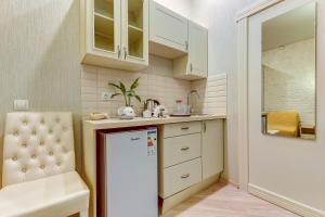 a small kitchen with a white refrigerator and a chair at Guest rooms on Marata 10 in Saint Petersburg