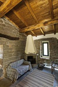 a living room with a couch and a stone wall at La Casedda in Luogosanto