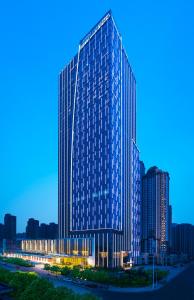 鄭州市にあるWanda Vista Zhengzhouの夜の高層ビル