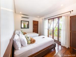 a bedroom with two beds and a large window at Balay Kogon in Carles