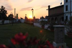 un tramonto in un giardino con una casa e fiori di Volivia Relais a Pegognaga