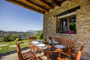 drewniany stół i krzesła na patio w obiekcie Alpujarra Cortijo Casilla Noguera w mieście Pórtugos