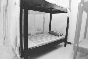 a black bunk bed with a pillow on it at Hikka Surf Hostel in Hikkaduwa