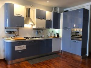 una cucina con armadi blu e banconi bianchi di Modern sunny apartment in residental area a Venezia