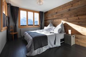 a bedroom with a large bed with a wooden wall at Alp n' rose in Hasliberg