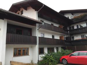 a red car parked in front of a white building at Bergmomente Neuschwanstein in Schwangau