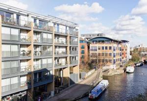 two buildings next to a river with a boat at Modern rooms in central London in London