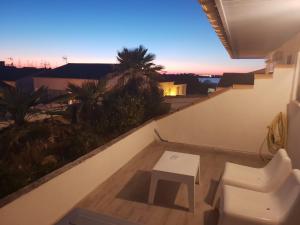 a room with a balcony with a table and a chair at Hotel Les Palmiers En Camargue in Saintes-Maries-de-la-Mer