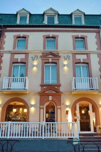 - un grand bâtiment blanc avec des fenêtres et un balcon dans l'établissement Villa Les Bains, à Houlgate