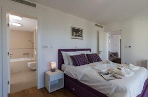a bedroom with a large bed and a bathroom at Apartments Nav in Dubrovnik +64 photos