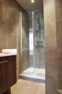 W łazience znajduje się prysznic ze szklanymi drzwiami. w obiekcie Villa Les Bains w mieście Houlgate