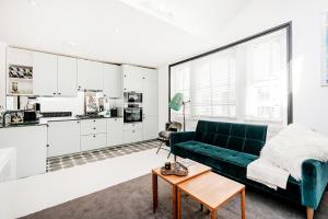 a living room with a green couch and a kitchen at Bright and stylish 1 bedroom apt in Notting Hill in London