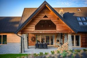 una casa de madera con techo de gambrel en Łabowska Chata - Basen, Sauna, Grota solna en Łabowa