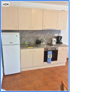a kitchen with white cabinets and a white refrigerator at Demianitza complex in Bansko