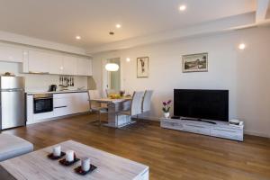 a living room with a large television and a kitchen at Apartments Nav in Dubrovnik
