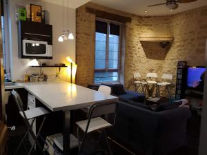 eine Küche mit einem Tisch und Stühlen im Zimmer in der Unterkunft Appartement DIJON Cité de la Gastronomie et du Vin - Arquebuse-Gare - A deux pas de toutes les commodités in Dijon