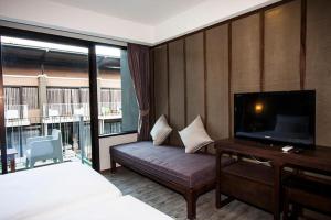 a hotel room with a bed and a flat screen tv at La Lune Beach Resort in Ko Samed