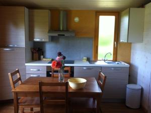 a kitchen with a wooden table with a vase of flowers on it at Domaine De Silvabelle in Mars-sur-Allier