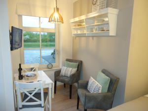 a small room with a table and chairs and a window at Bed & Breakfast Zeeduinsepoort met Sauna in Oostkapelle