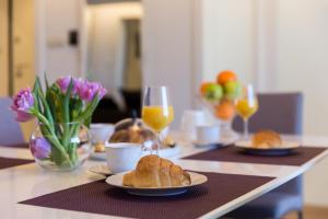 een tafel met twee borden brood en glazen sinaasappelsap bij Apartments Nav in Dubrovnik