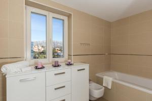 een badkamer met een toilet, een bad en een raam bij Apartments Nav in Dubrovnik