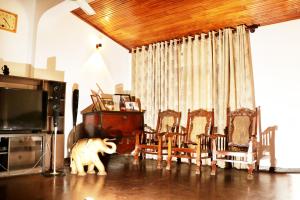 Habitación con mesa, sillas y TV. en Ariyadasa Guest House, en Galle