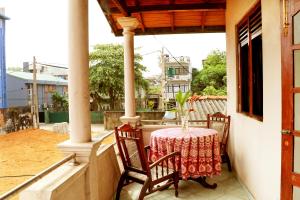 a table and chairs on the balcony of a house at Ariyadasa Guest House in Galle
